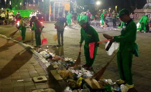 Petugas DLHK Kota Denpasar saat membersihkan sampah pada Jumat (28/3/2025) usai pengarakan ogoh-ogoh pada Ngerupuk serangkaian Nyepi Saka 1947.