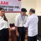 Kadisnaker Gianyar mengalungkan kartu peserta pada pembukaan Pelatihan Berbasis Kompetensi (PBK) Non Boarding Tahun 2026.